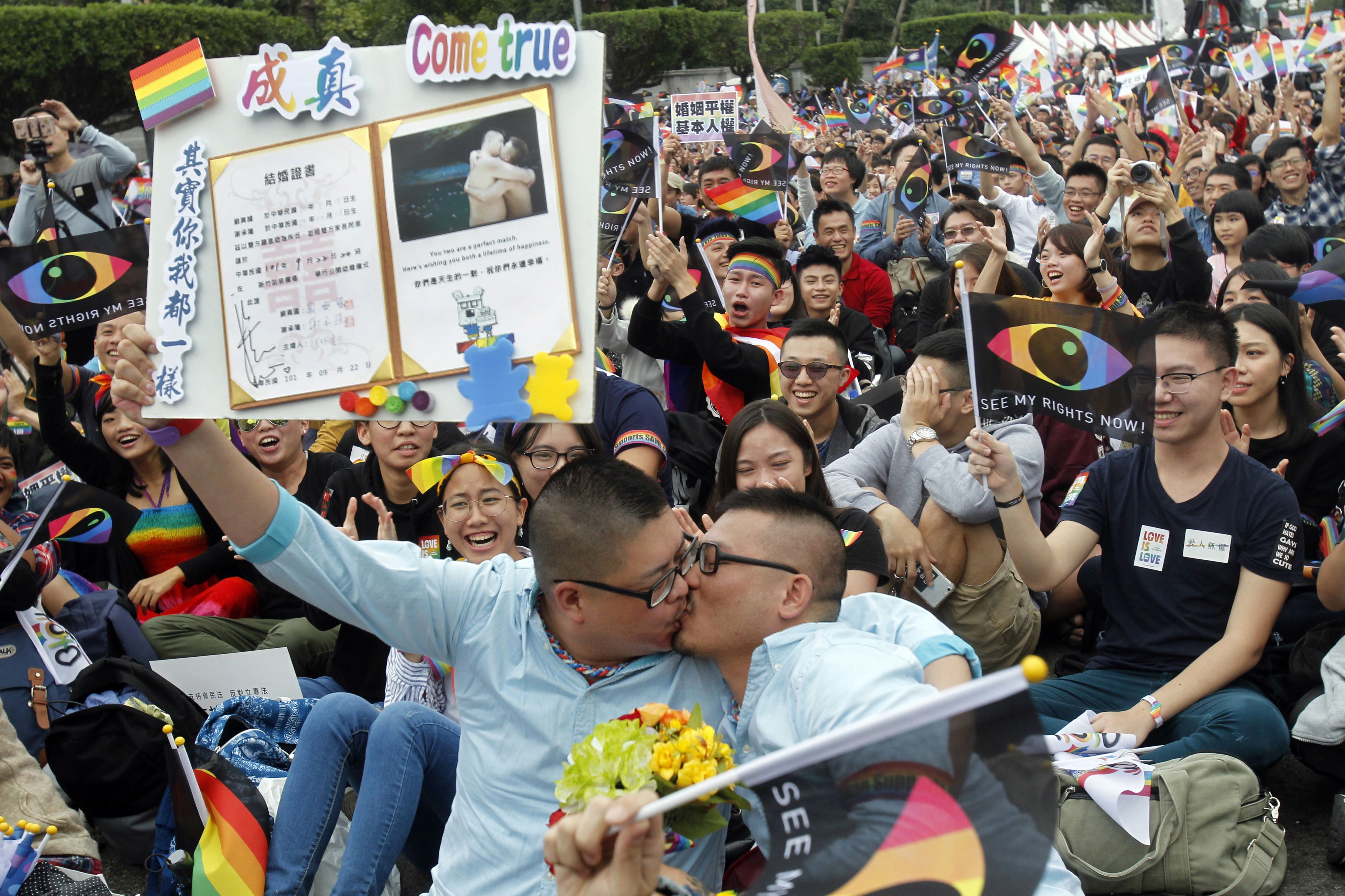 世界人权日当天,一对夫妇在台北举行的支持同性婚姻提案集会上亲吻并手持结婚证。台湾选民于 2018 年 11 月 24 日星期六进行了同性婚姻公投。
